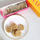 Ginger snap cookies next to open box with sleeve of cookies.