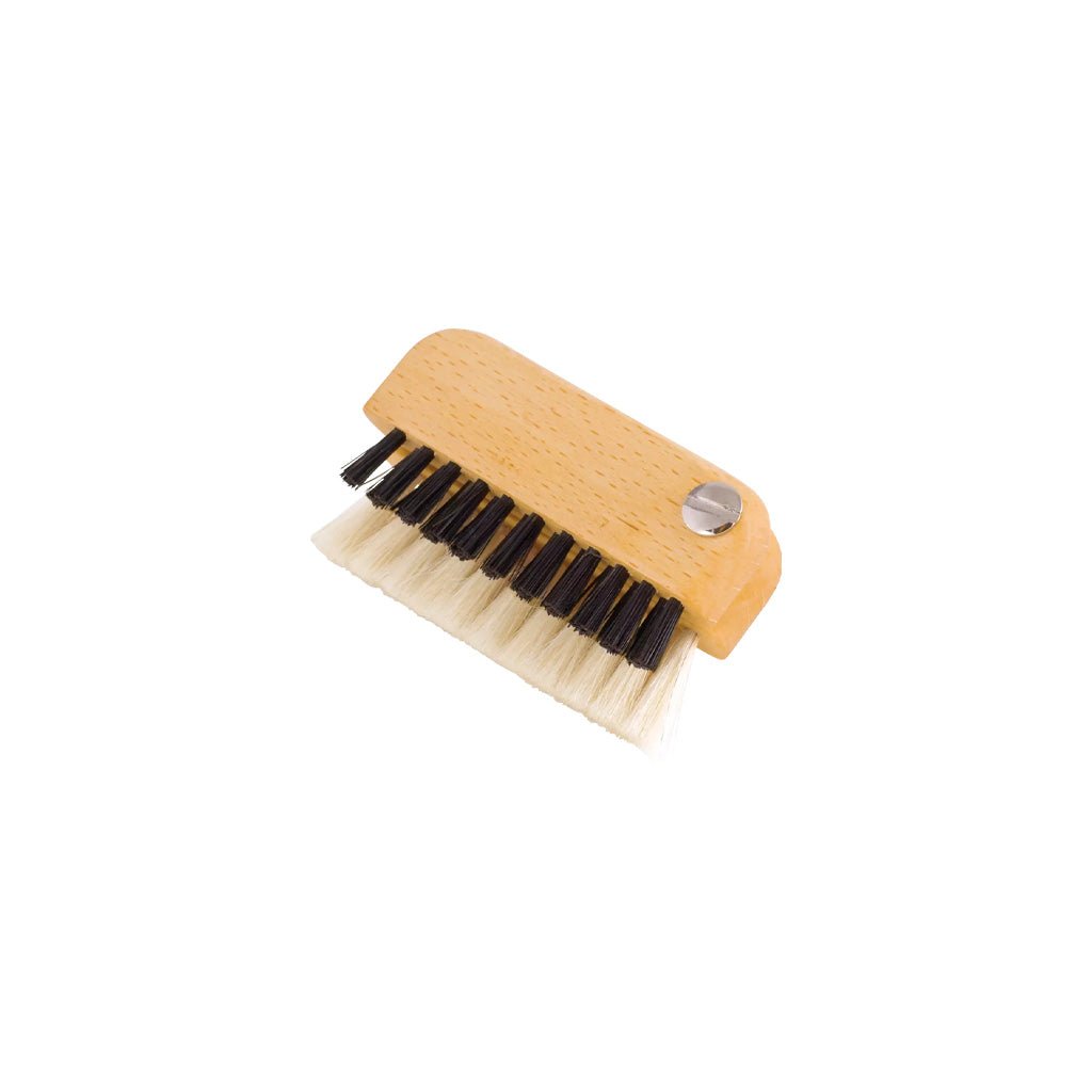 Small wooden laptop brush closed with one row or black bristles and one with light-colored bristles on white background