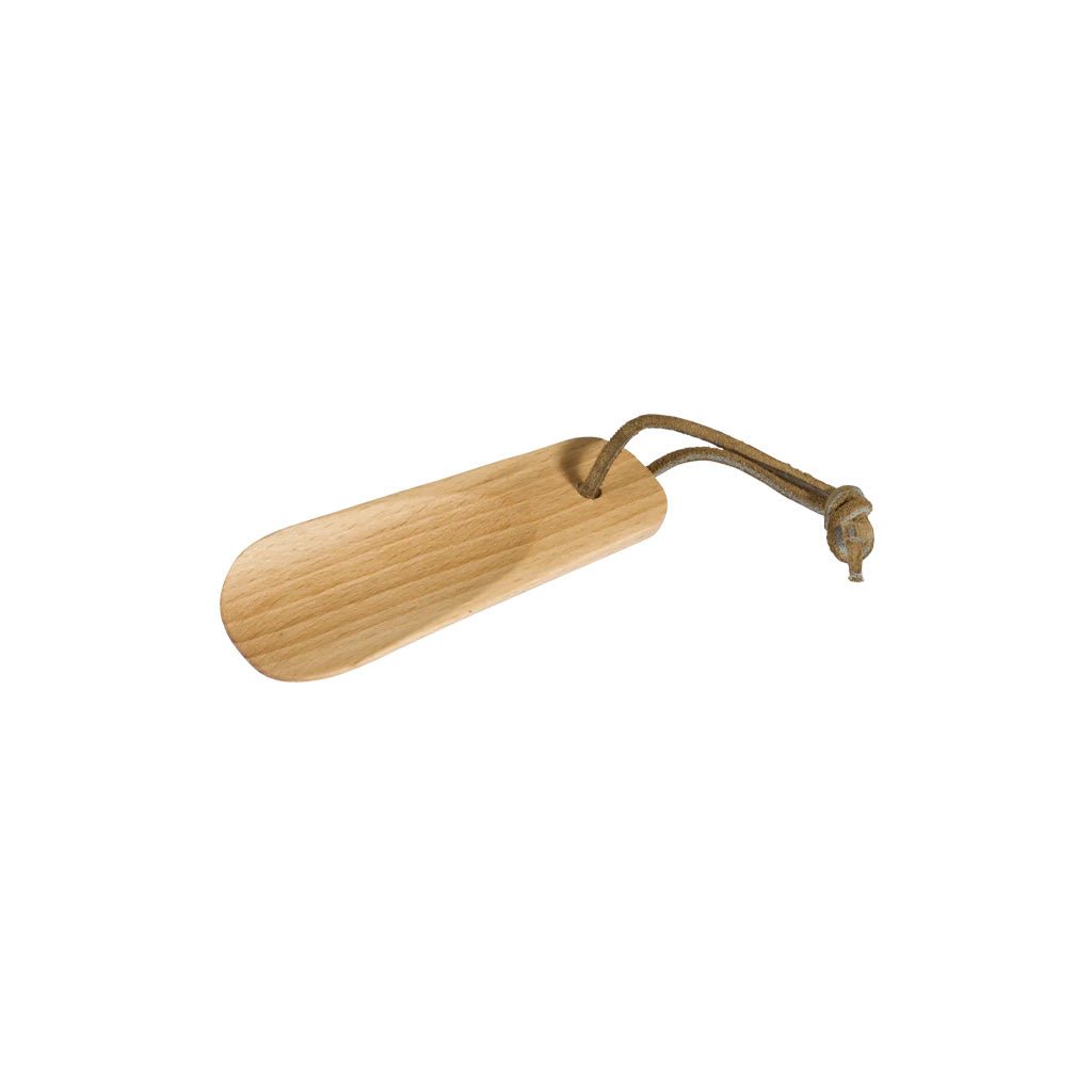 A light natural wood shoe horn with a brown leather lanyard and knot, shown on a plain white background.