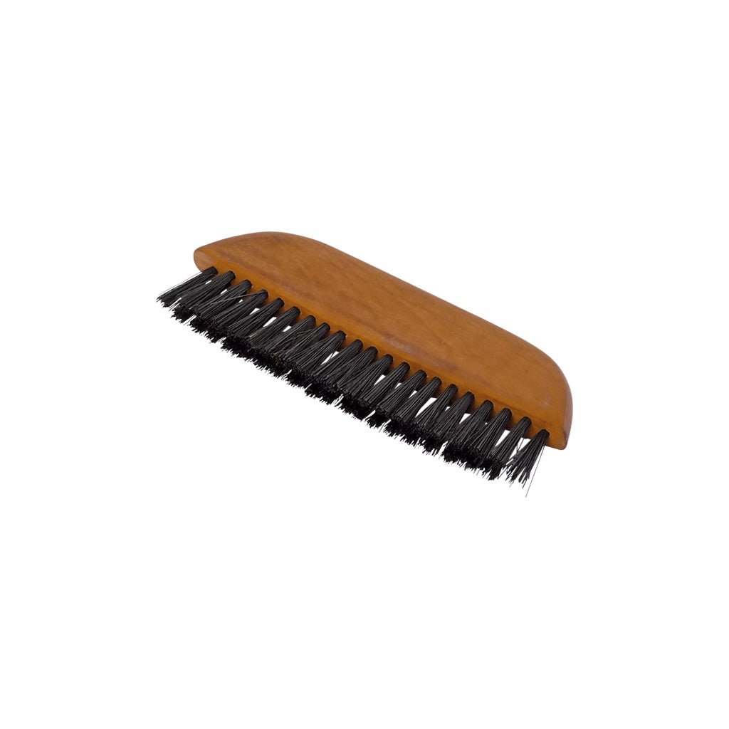 A wooden pocket clothes brush with black hog hair bristles on white background