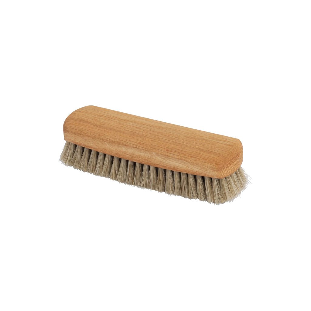 Small wooden rectangular shoe shine brush with natural bristles on white background
