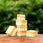 Six blocks of SallyeAnder Calendula Dandelion Essential Soap on wooden table outside