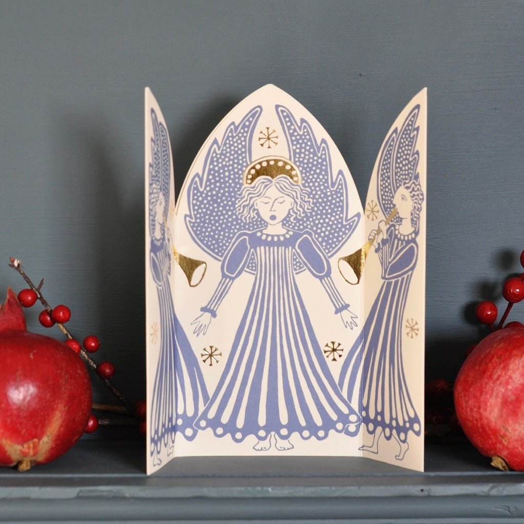 Triptych card open standing upright on mantel.