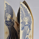 Close-up of a triptych card with blue angel illustration and gold foil details.