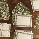 Green Ivy Notecard and Envelope Set arranged on a wooden table, featuring botanical envelopes, bordered cards, and labels.