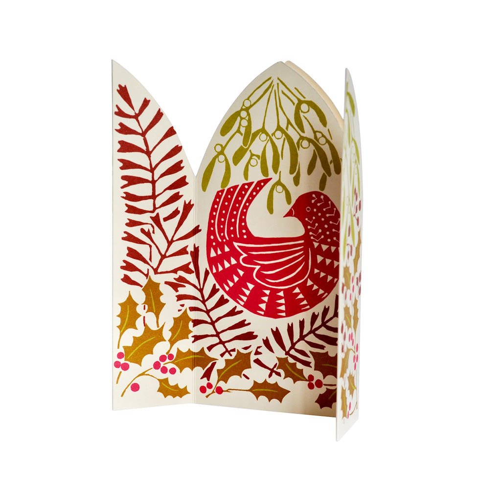An unfolded festive paper greeting card featuring a stylized bird in pink and red, surrounded by mistletoe, holly leaves, and berries on a white background.