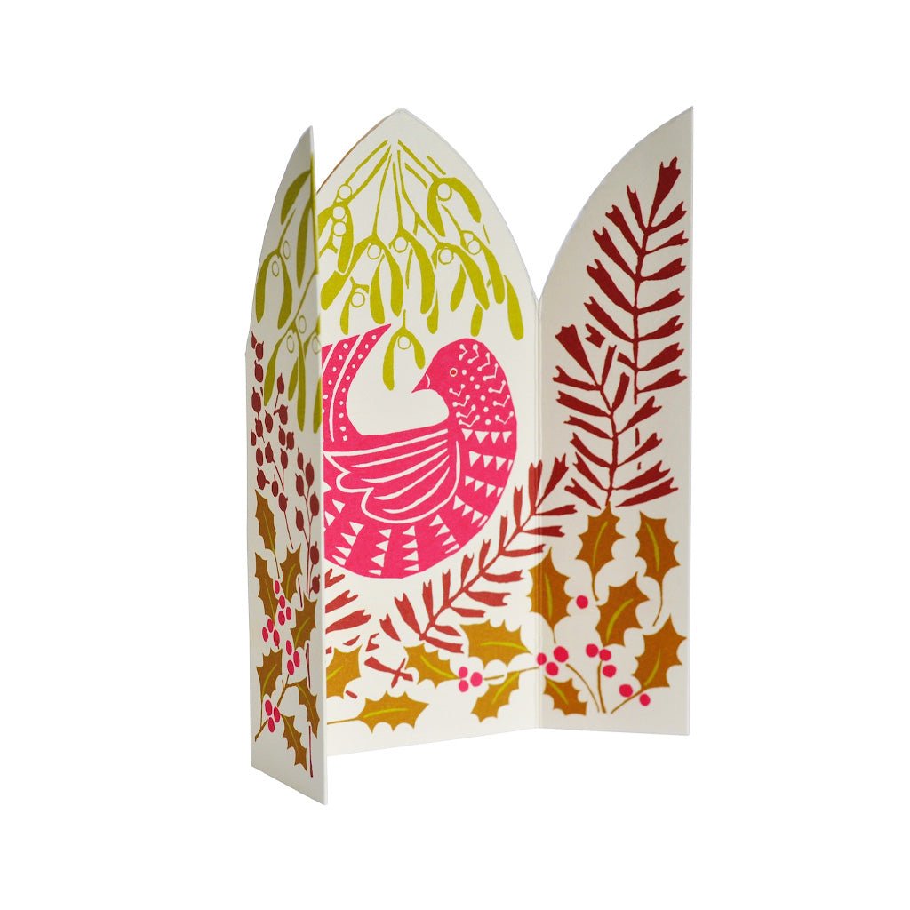 An unfolded festive paper greeting card featuring a stylized bird in pink and red, surrounded by mistletoe, holly leaves, and berries on a white background.
