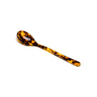 Tortoiseshell-patterned cereal spoon on a white background