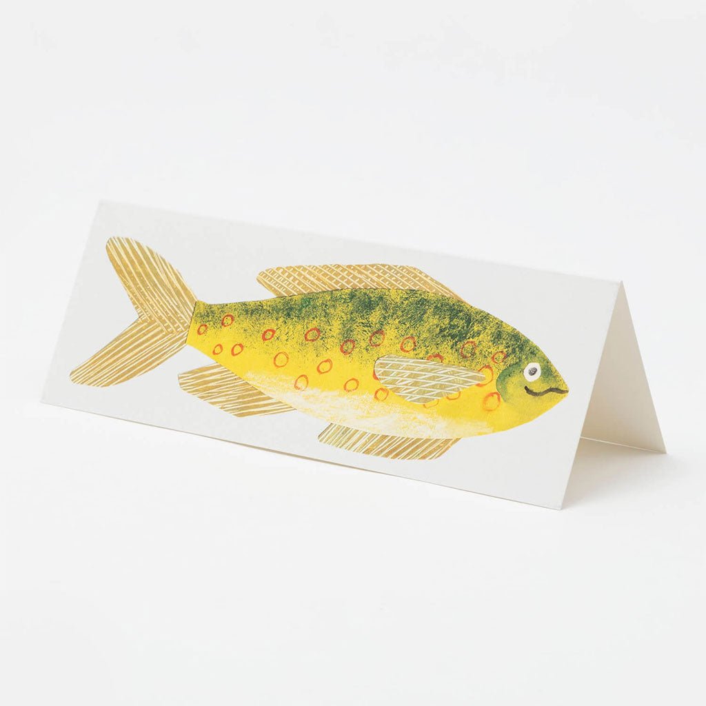 Long card with yellow fish standing on table