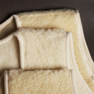 Close-up showing slight variations in shade between three natural woolen vests. 
