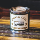 Citronella candle in a tin with a label on a wooden surface