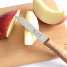 Vegetable knife with wooden handle and windmill logo on a cutting board with apples