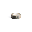 A roll of decorative washi tape with a black background and beige typographic print.