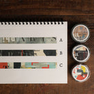 Three rolls of decorative washi tape with vintage-style collage patterns and text, labeled A,B and C.