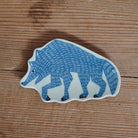 A ceramic wolf-shaped dish with a blue and white hand-painted wolf design, placed on a rustic wooden surface.