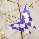 Blue and white origami butterfly on branch