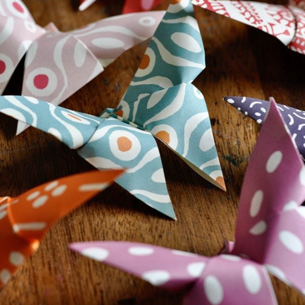 Colorful paper origami butterflies on a wooden surface