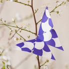Blue and white origami butterfly on branch