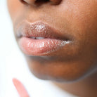 Model with lip salve on lips.