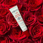 Tube of rose salve on bed of red roses.