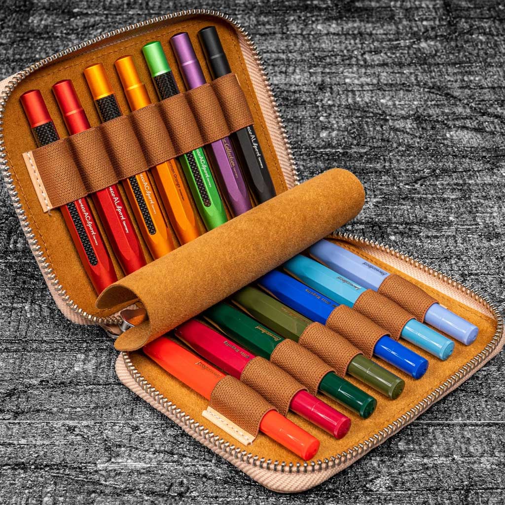 Set of colorful Kaweco pens in a brown case on a textured surface