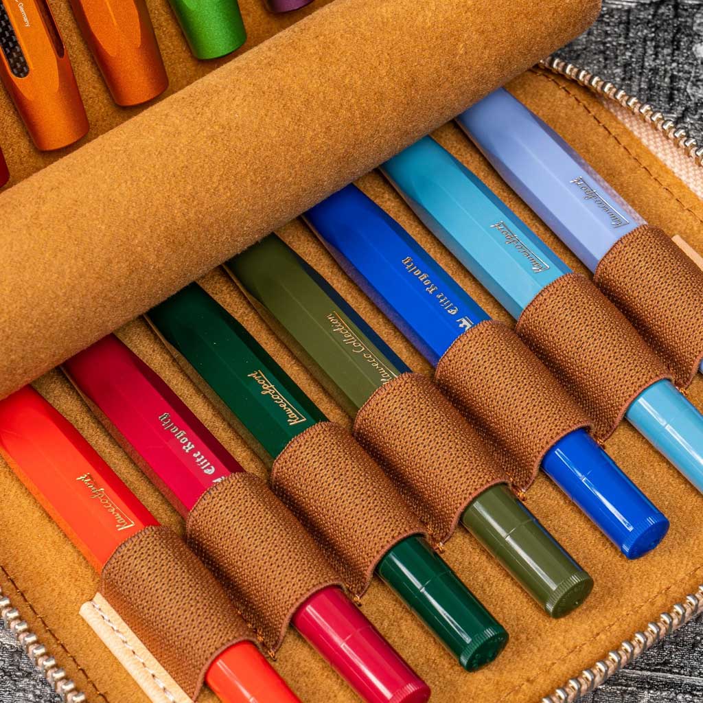 Set of colorful Kaweco pens in a brown case on a textured surface