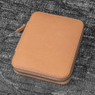 Natural undyed leather zippered pen case on textured surface
