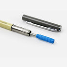 Blue ink refill inserted in yellow pen on white surface