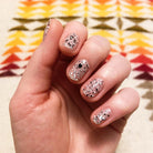 Hand wearing cookies and cream sheer glittery nail polish