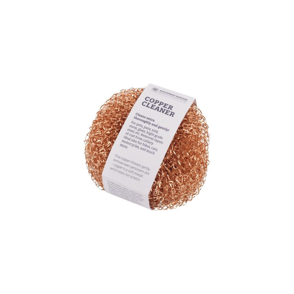 Round copper scrubber with label on a white background