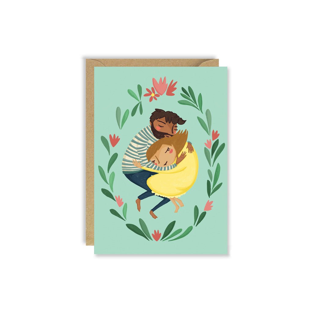 Greeting card with illustration of two people hugging surrounded by flowers on a light green background