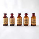 Five small bottles of El Guapo mixers on a white background