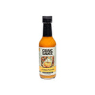 A bottle of Craic Sauce Golden Pumpkin hot sauce on a plain white background. 