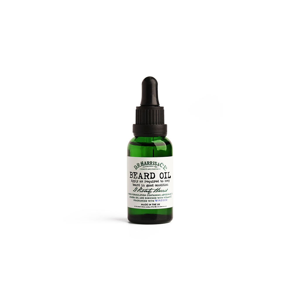 Green bottle of D. R. Harris beard oil on white background