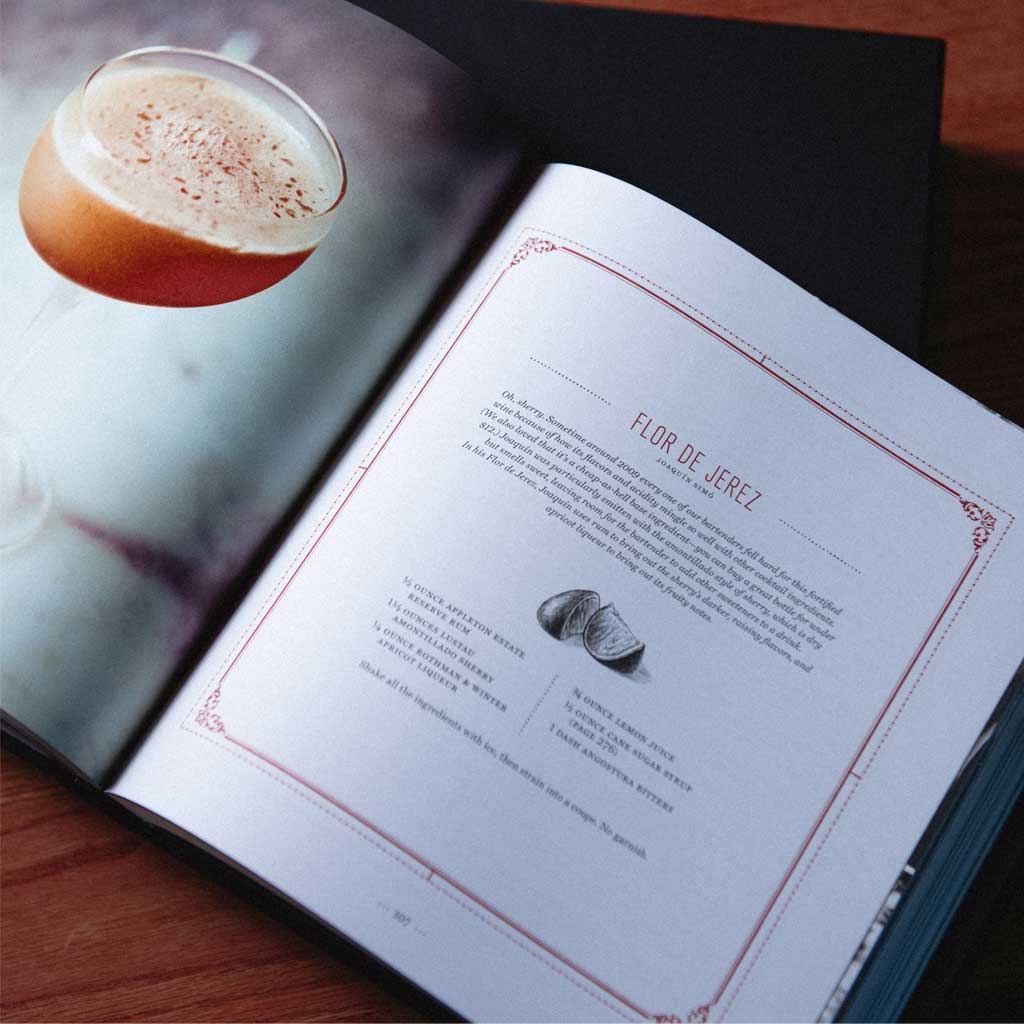 Open book with a page showing 'Flor de Jerez' recipe and a close-up of a cocktail on the left.