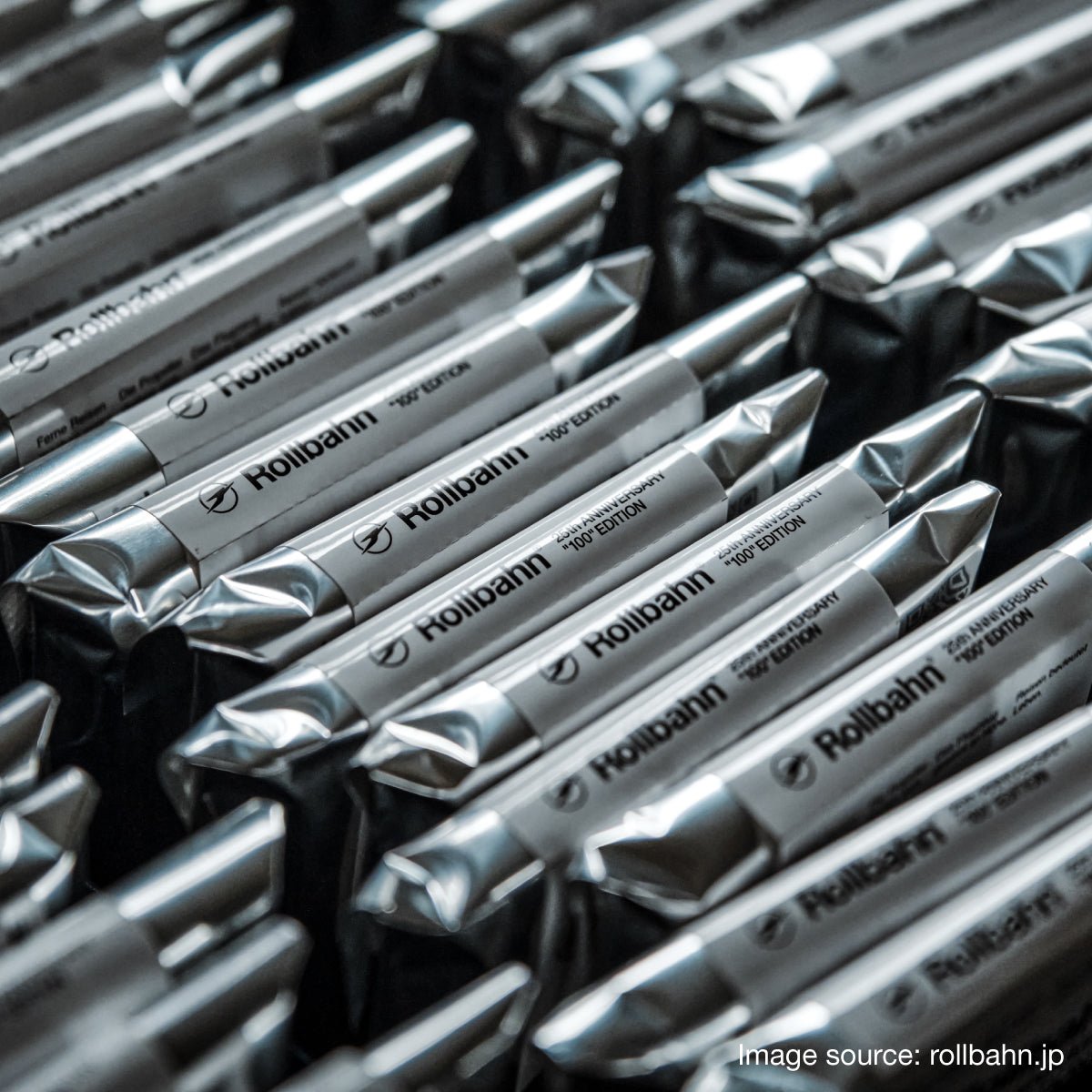 Close-up of multiple silver foil-wrapped Rollbahn mini noteboos, arranged in neat rows with the brand name clearly printed on each package.