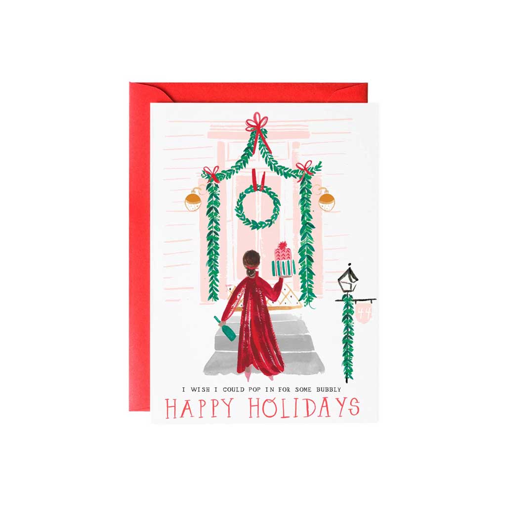 Holiday card featuring a person looking into a window decorated with Christmas decorations.