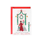 Holiday card featuring a person looking into a window decorated with Christmas decorations.