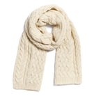 Cream-colored cable knit scarf on a white background