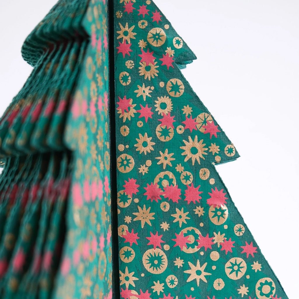 Screen-printed details on Christmas tree paper decoration.