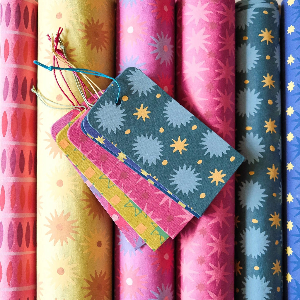 Patterned gift tags on top of rolls of wrapping paper.
