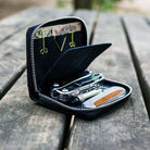 Open black wallet with tools on a wooden surface