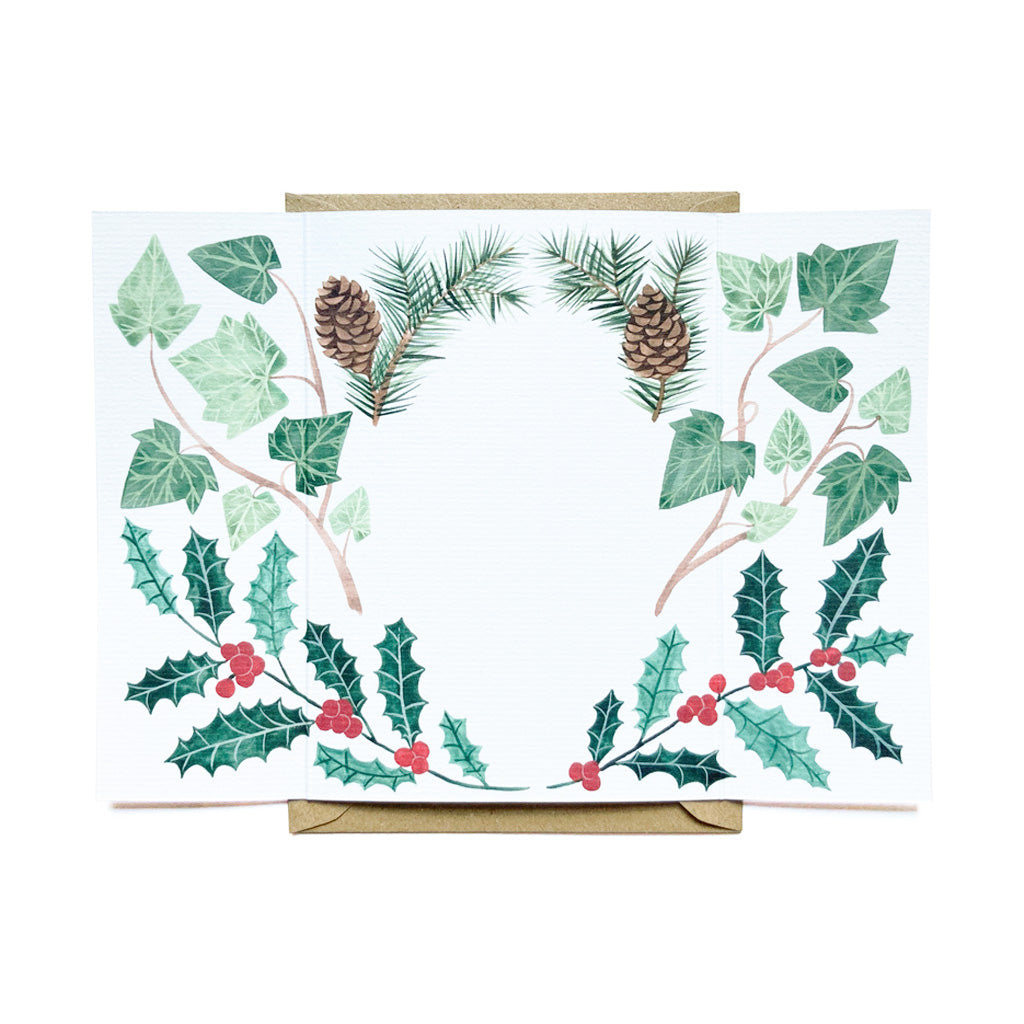 An open card with illustrations in front of a kraft paper envelope.