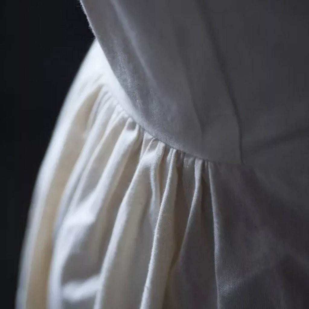 Close-up of a white dress with a dark background