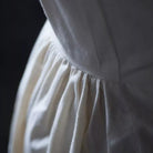 Close-up of a white dress with a dark background