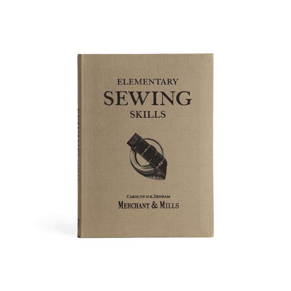 Book titled 'Elementary Sewing Skills' by Merchant & Mills on a beige background