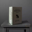 Merchant and Mills Elementary Sewing Skills Book on gray stool on gray background