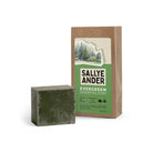 Dark green SallyeAnder evergreen essential soap next to packaging on white background