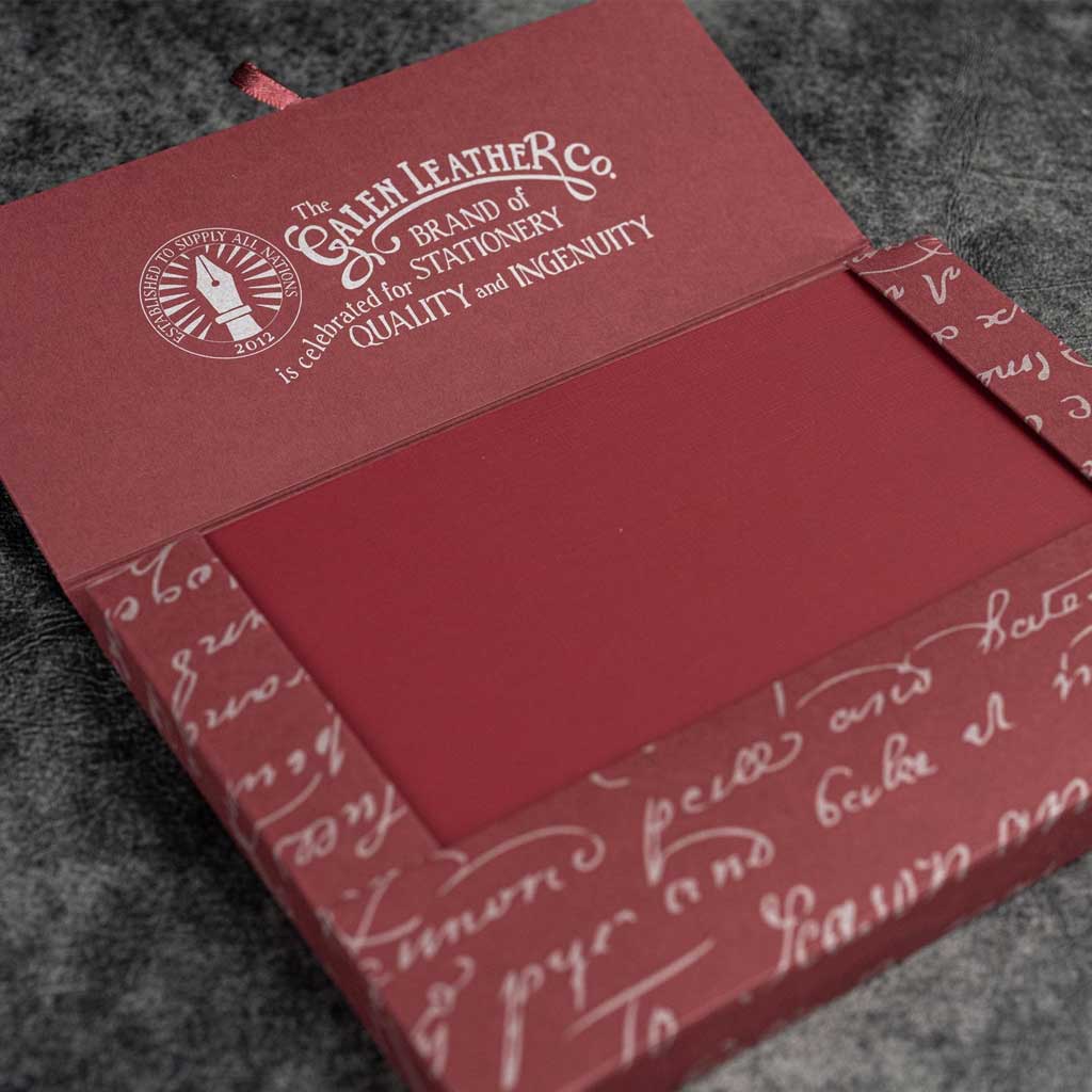 Red notebook in box packaging on dark surface