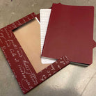 Red notebook with packaging on a textured surface